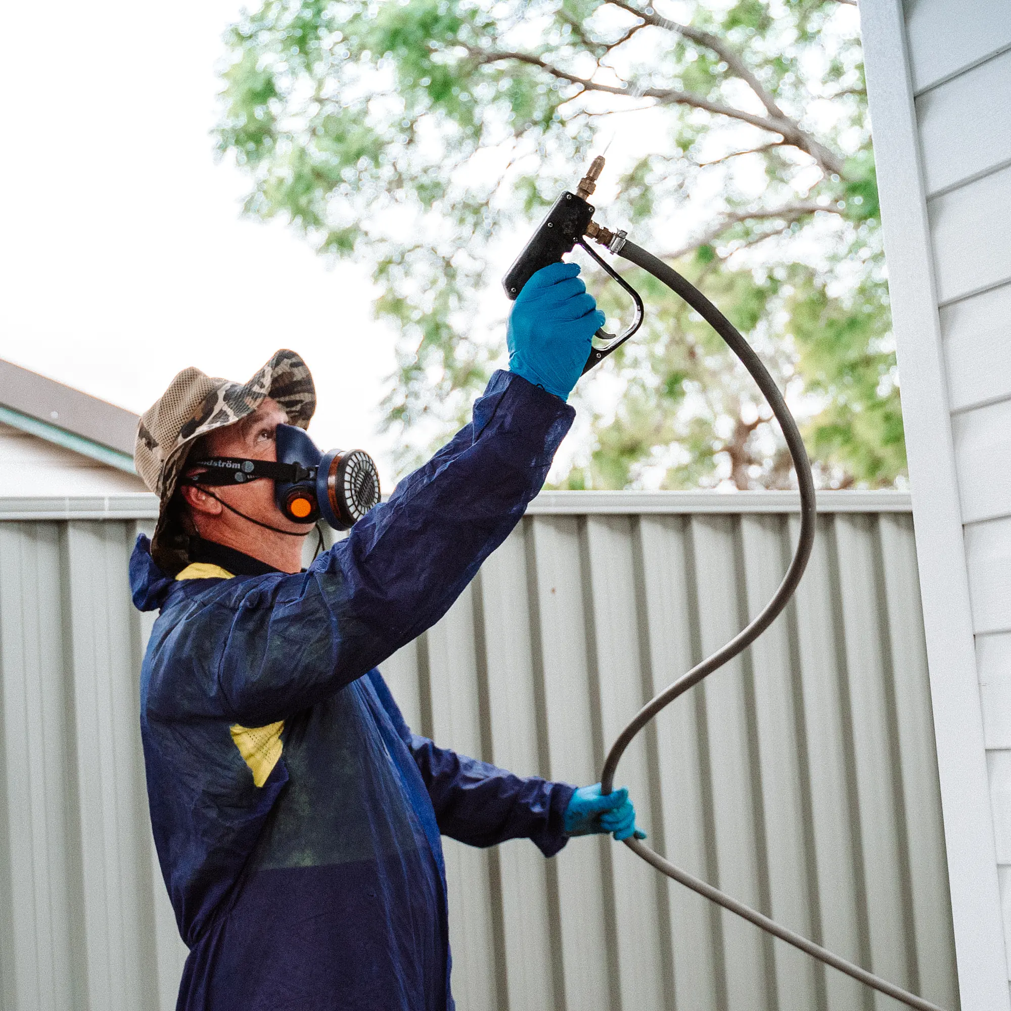 Bug Free technician applying a perimeter treatment to the eaves of a Sydney home